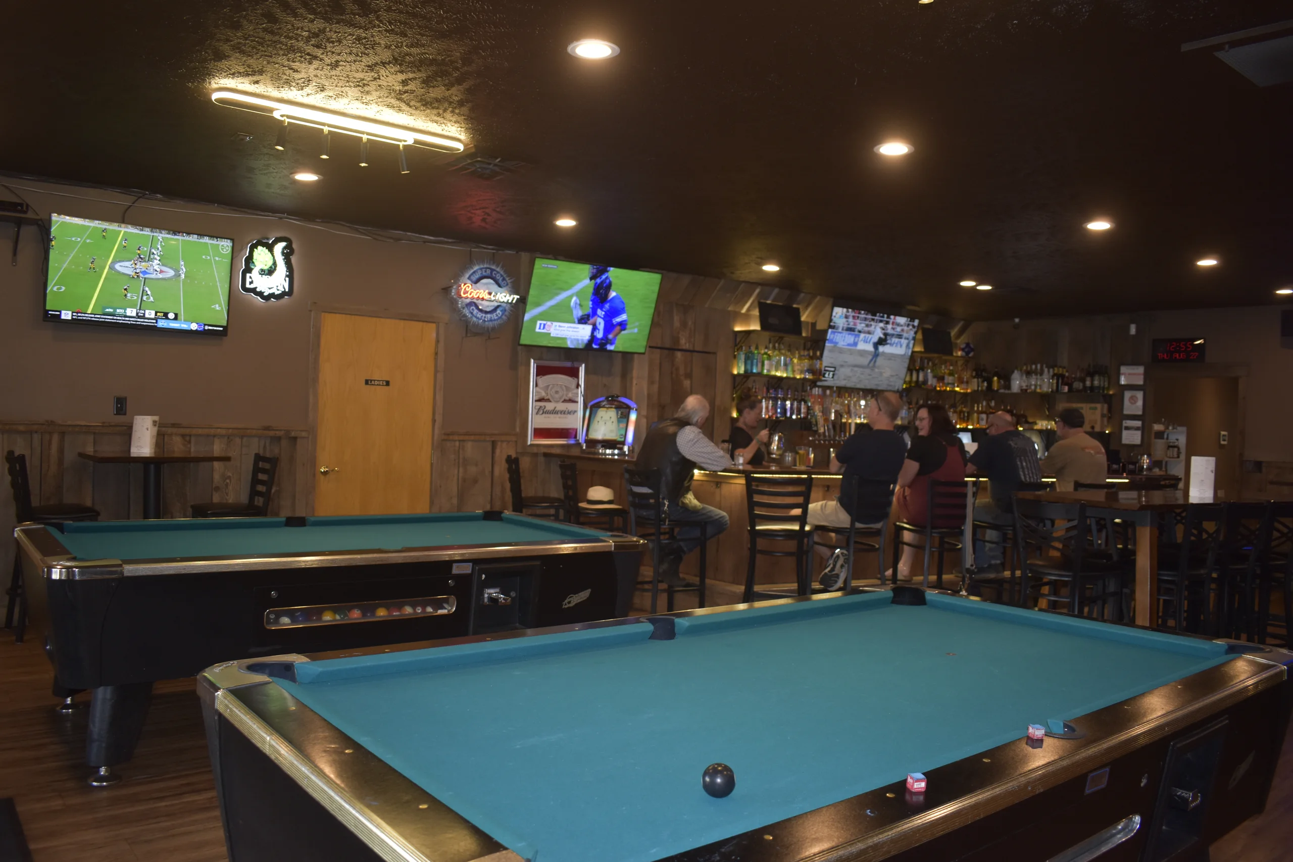 Guests at the bar, with pool tables and televisions in the room